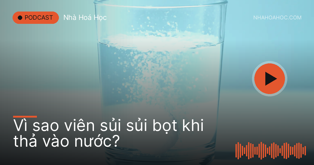 Viên thuốc trắng sủi bọt tan trong ly nước trong